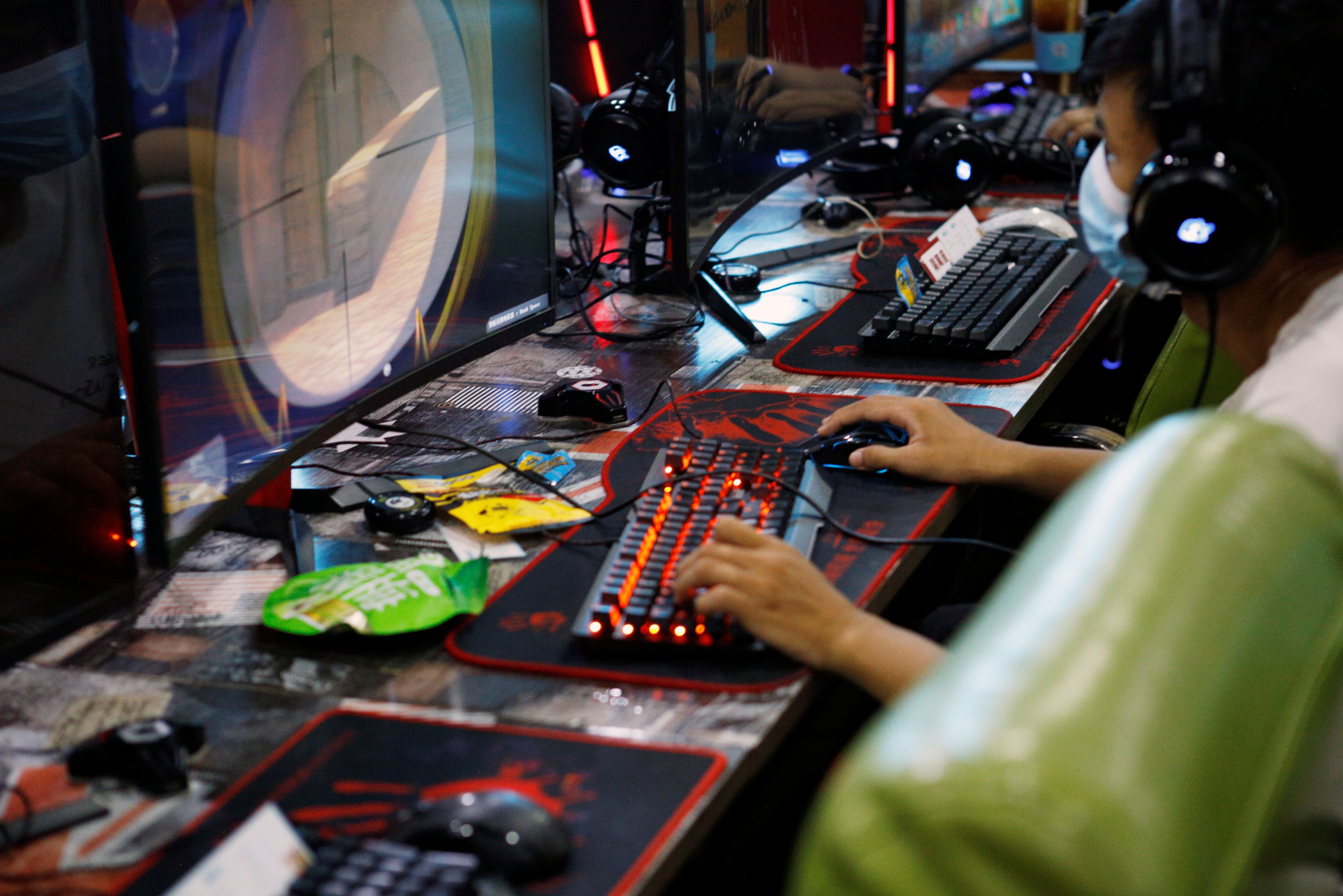 A man plays online game on a computer at an internet cafe in Beijing.
