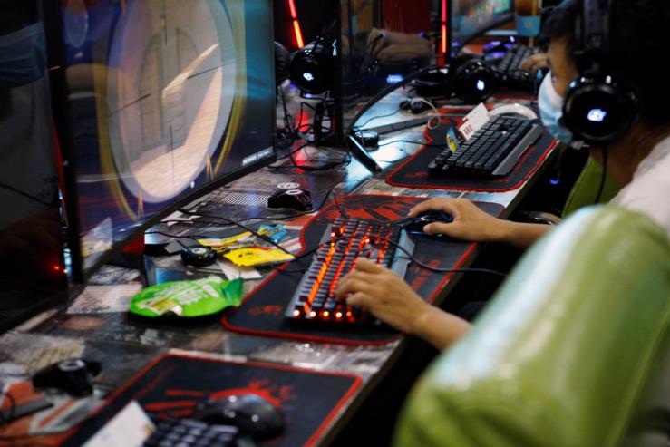 A man plays online game on a computer at an internet cafe in Beijing.