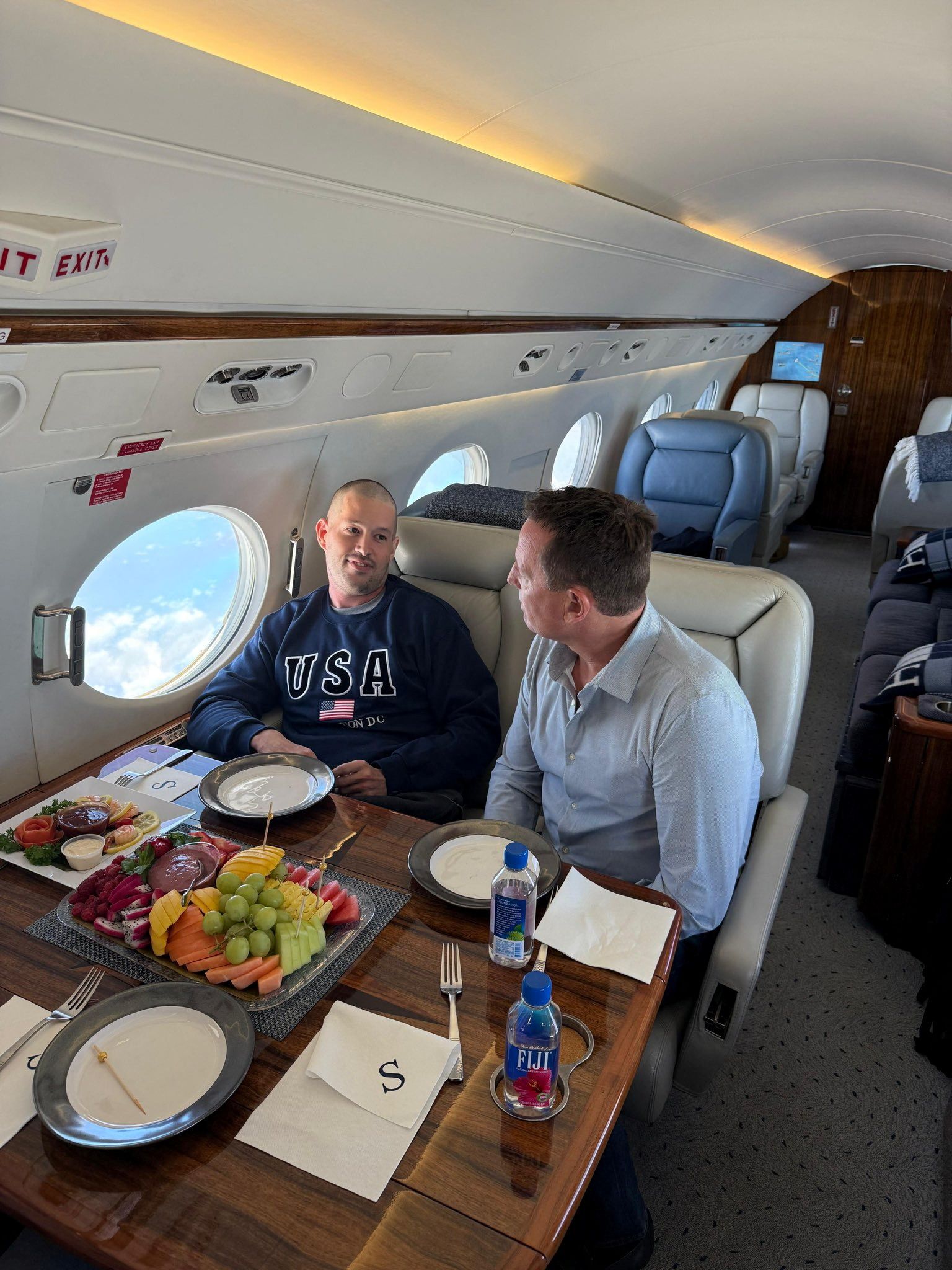 Richard Grenell and Air Force veteran Joseph St. Clair, released after months of detention in Venezuela, talk on board an aircraft, in a picture shared on social media.
