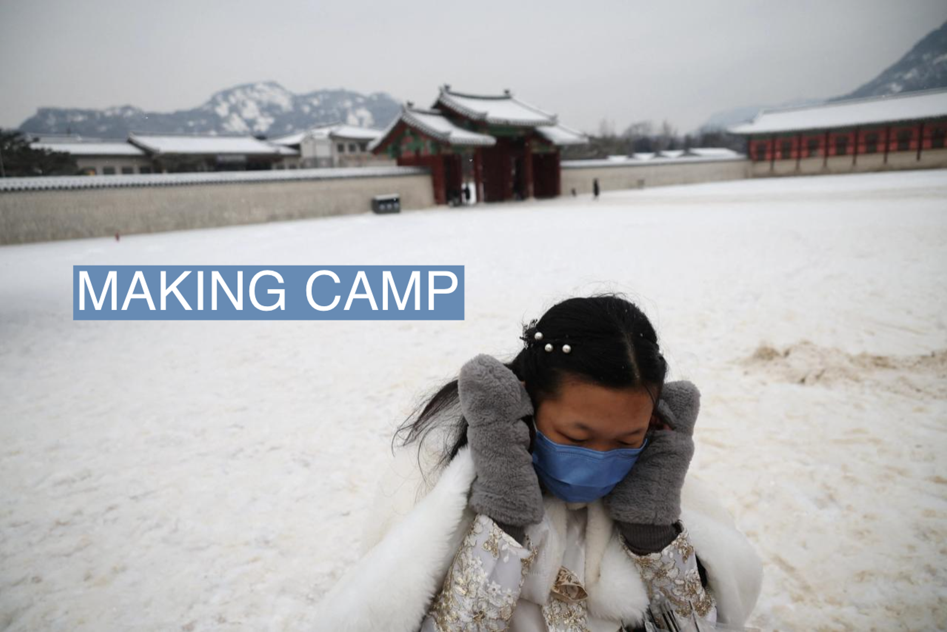 A woman wearing Korean traditional costume 'Hanbok' covers her face with hands to keep warm as it snows on a cold winter day at Gyeongbokgung Palace in Seoul, South Korea, January 26, 2023.