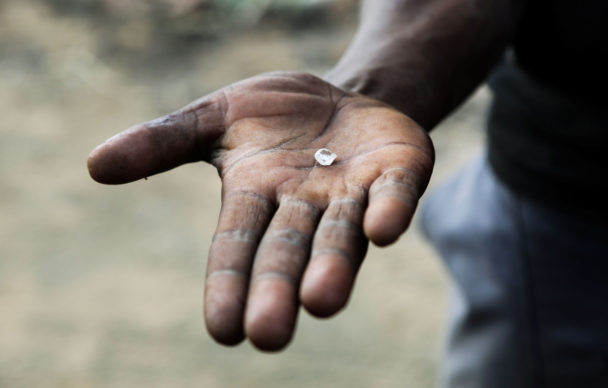 An artisanal miner holds an uncut diamond in his hand in Kimberley, South Africa.
