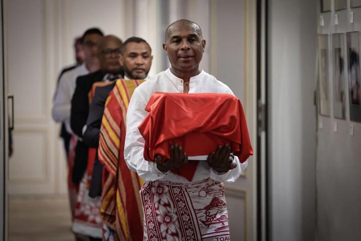 A man carries one of the three Sakalava skulls