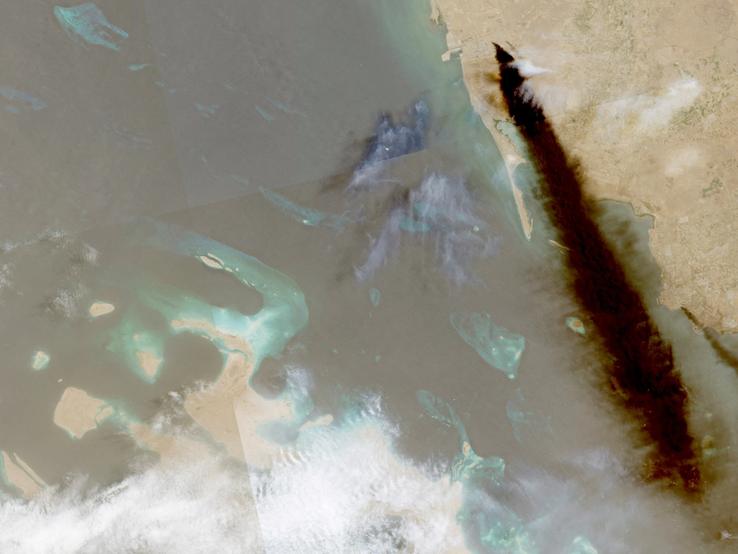 A composite satellite image shows trail of smoke rising from an oil facility, in Jizan, Saudi Arabia
