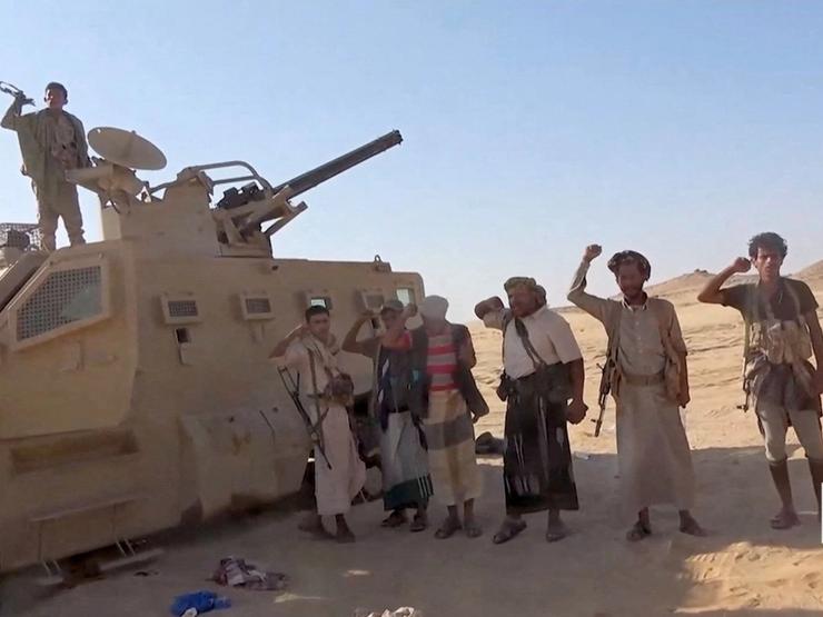 Houthi fighters pose next to a captured vehicle following what they said was an attack on Saudi-backed forces in Yemen.