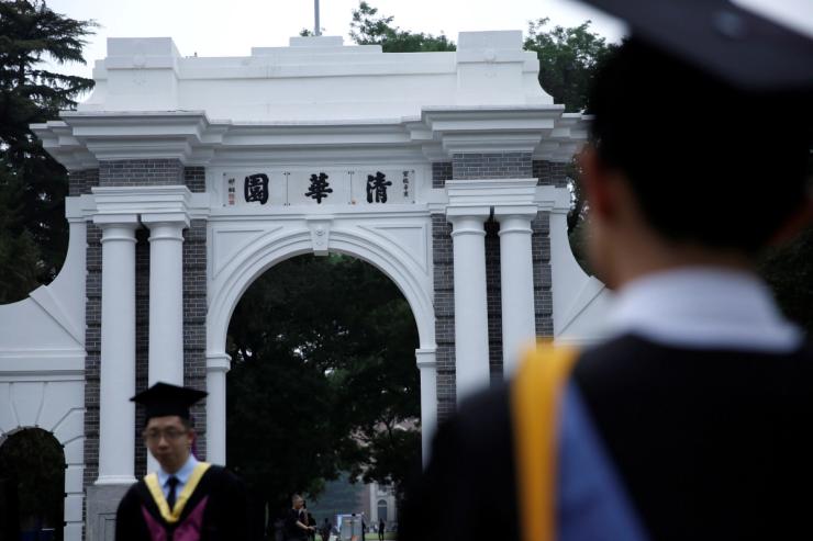 Undergraduate students pose for photos at an old gate of Tsinghua University.