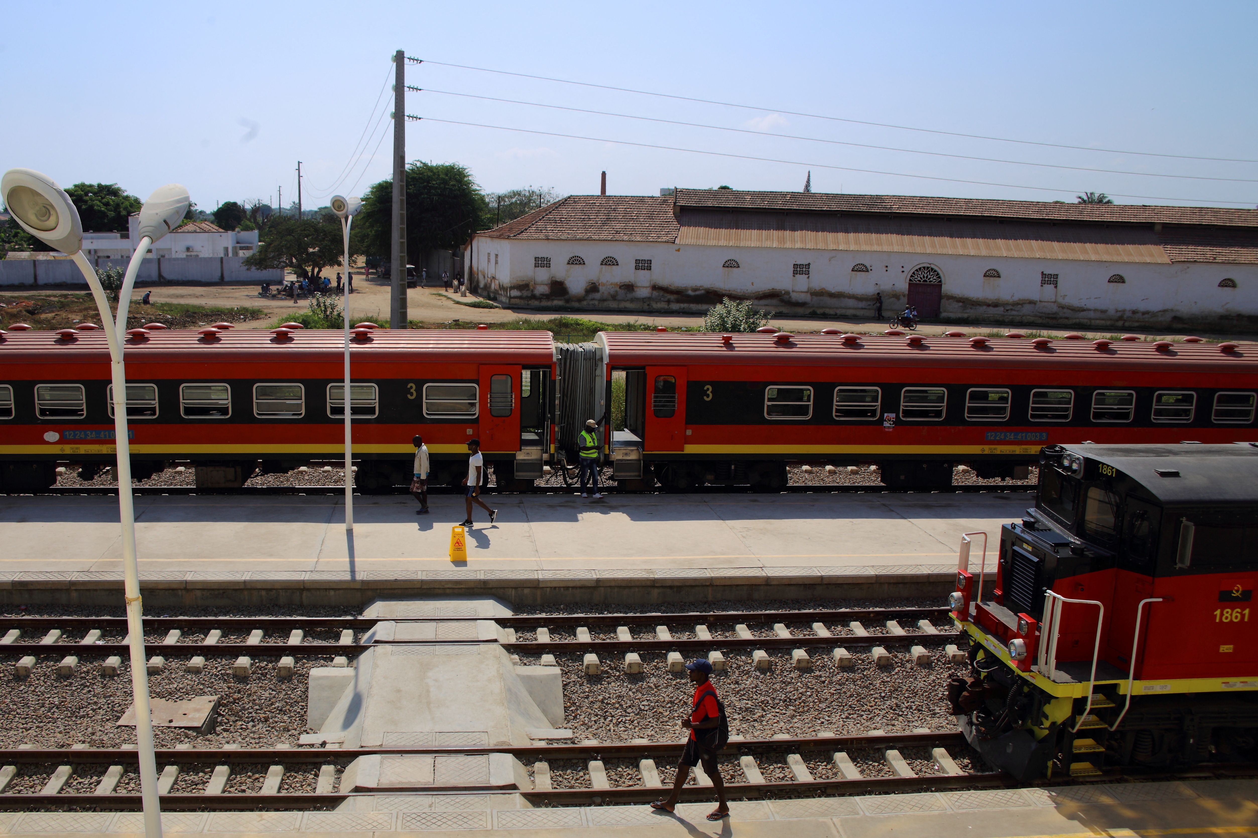 Locals walk past trains parked at Lobito station, which forms part of the Benguela Railway line, in Lobito.