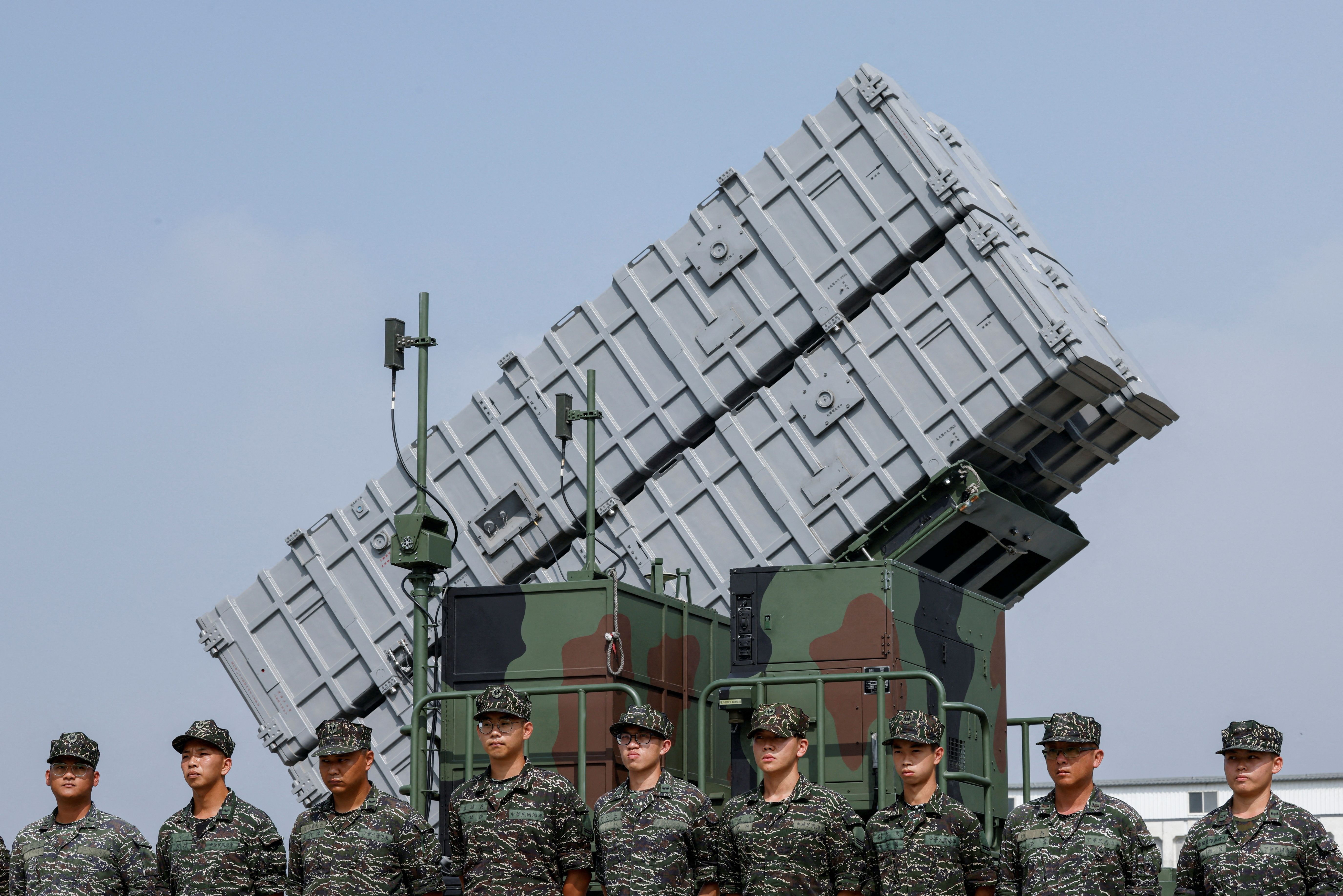Members of the Taiwanese Navy stand in front of Hsiung Feng III mobile missile launcher