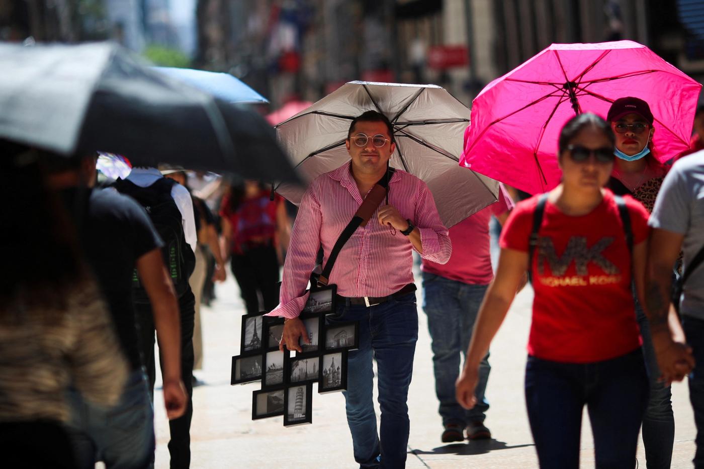 People walk during a period of high temperatures in Mexico City, Mexico June 13, 2023. REUTERS/Henry Romero