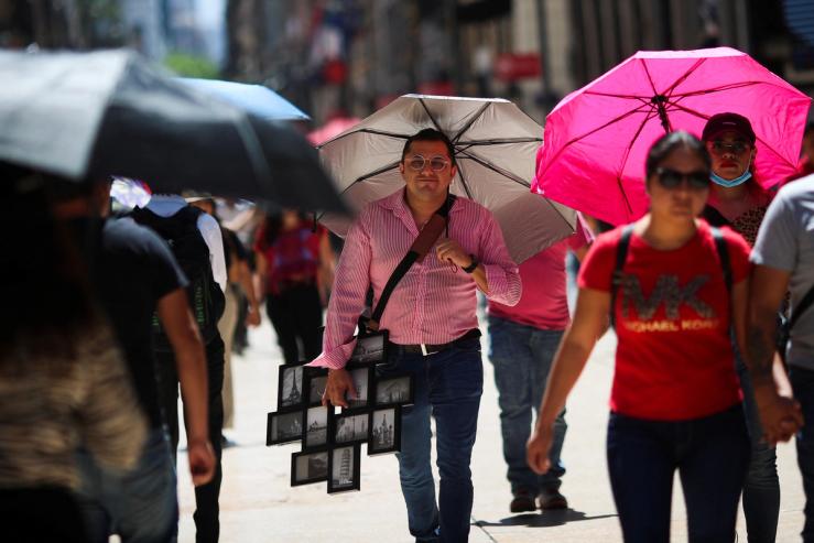 People walk during a period of high temperatures in Mexico City, Mexico June 13, 2023. REUTERS/Henry Romero