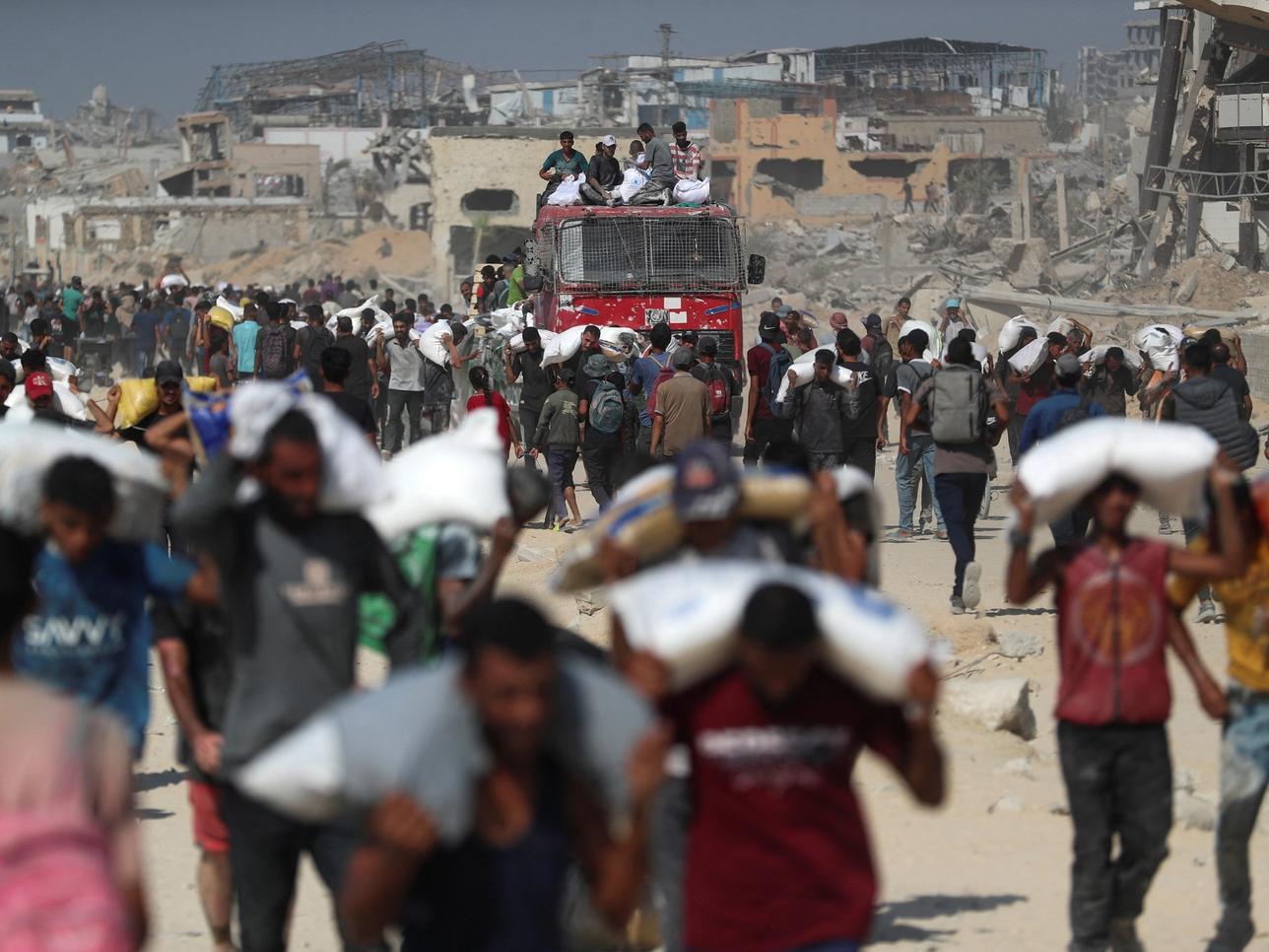 Palestinians carry aid supplies that entered Gaza through Israel.