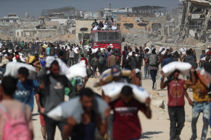 Palestinians carry aid supplies that entered Gaza through Israel.
