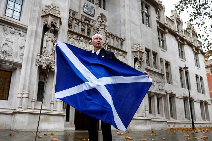 A pro-Scottish independence campaigner poses with a Scottish flag outside the United Kingdom Supreme Court in a case to decide whether the Scottish government can hold a second referendum on independence next year without approval from the British parliament, in London, Britain November 23, 2022.