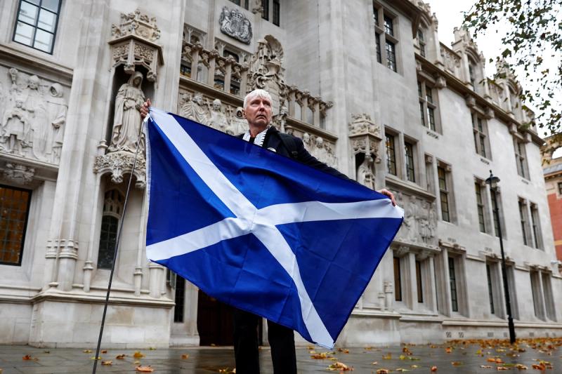 A pro-Scottish independence campaigner poses with a Scottish flag outside the United Kingdom Supreme Court in a case to decide whether the Scottish government can hold a second referendum on independence next year without approval from the British parliament, in London, Britain November 23, 2022.