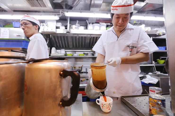 Staff making Hong Kong-style milk tea at Ngan Lung Catering Group (Cha Chaan Teng) in Mei Foo.