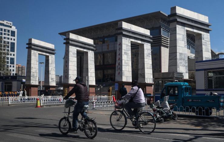 Flagship People ride bicycles near the entrance to Inner Mongolia University of Science and Technology in Baotou