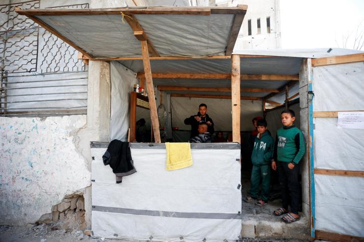 A barber cuts a client’s hair amid the wreckage in Gaza.