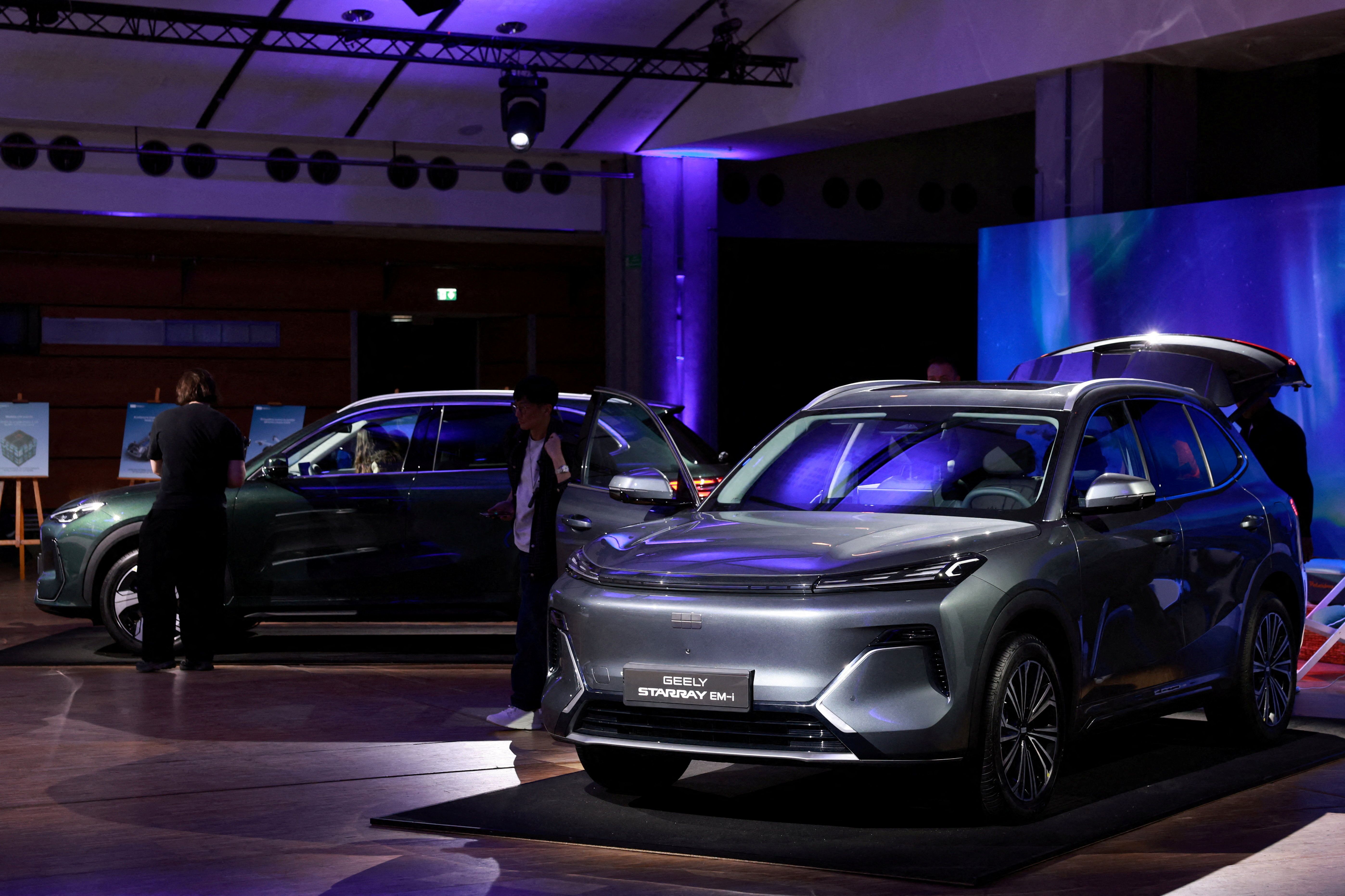 Journalists look at the Geely Starray EM-i car, a mid-sized plug-in hybrid SUV, presented during a press conference for the launching of Geely Auto France, in Paris, France,