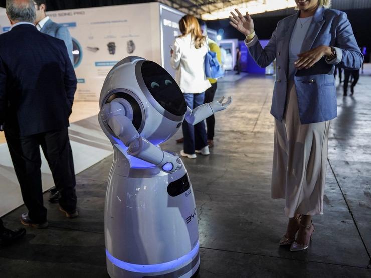 A woman dances with a robot during an event launching the Song Pro, a hybrid-electric SUV by Chinese automaker BYD in Mexico City, Mexico,