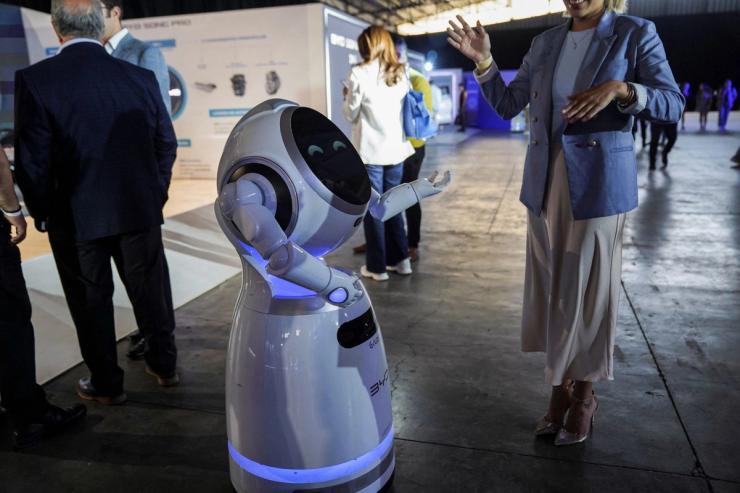 A woman dances with a robot during an event launching the Song Pro, a hybrid-electric SUV by Chinese automaker BYD in Mexico City, Mexico,