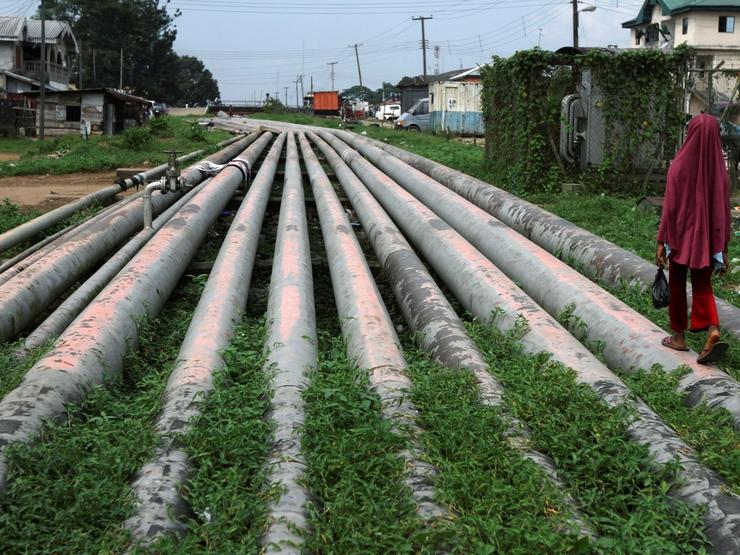 A girl walks on a gas pipeline running through Okrika community near Nigeria’s oil hub city of Port Harcourt.