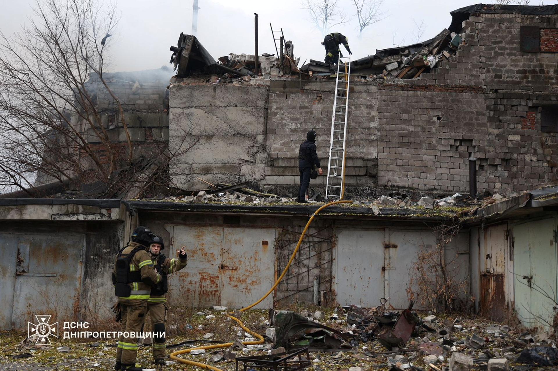 Firefighters work at the site of a Russian missile strike, amid Russia’s attack on Ukraine, in Dnipro.