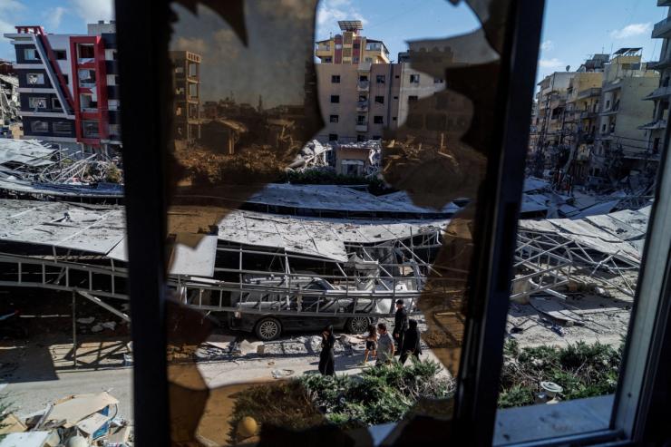 People walk past rubble at the site of an Israeli strike following a deal between the U.S. and Iran in Tyre, southern Lebanon.