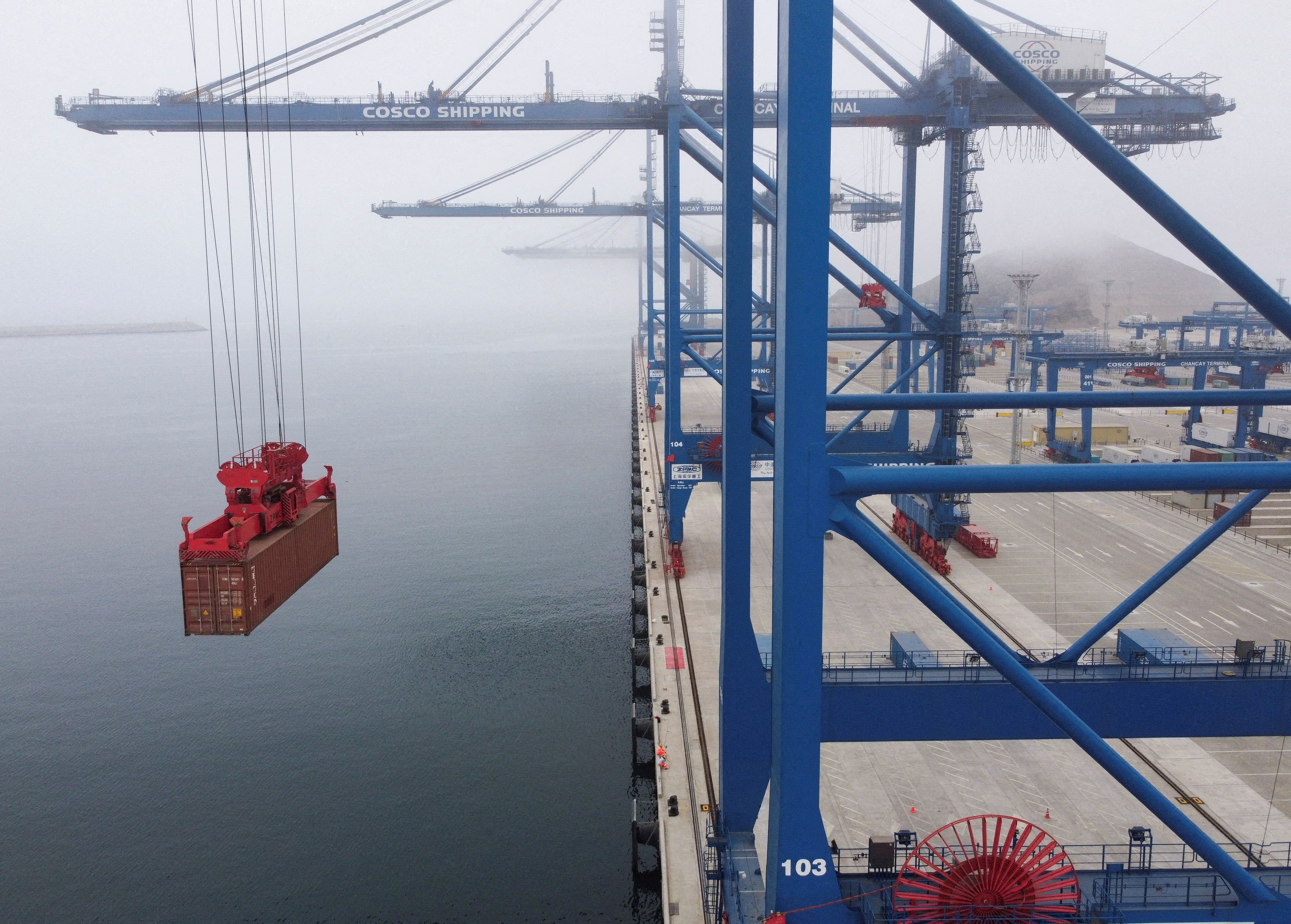 A drone view shows a crane moving a container at the new megaport being built by China’s state-owned Cosco Shipping, promising to shorten sea routes to Asia for Peruvian and some Brazilian goods, in Chancay, Peru