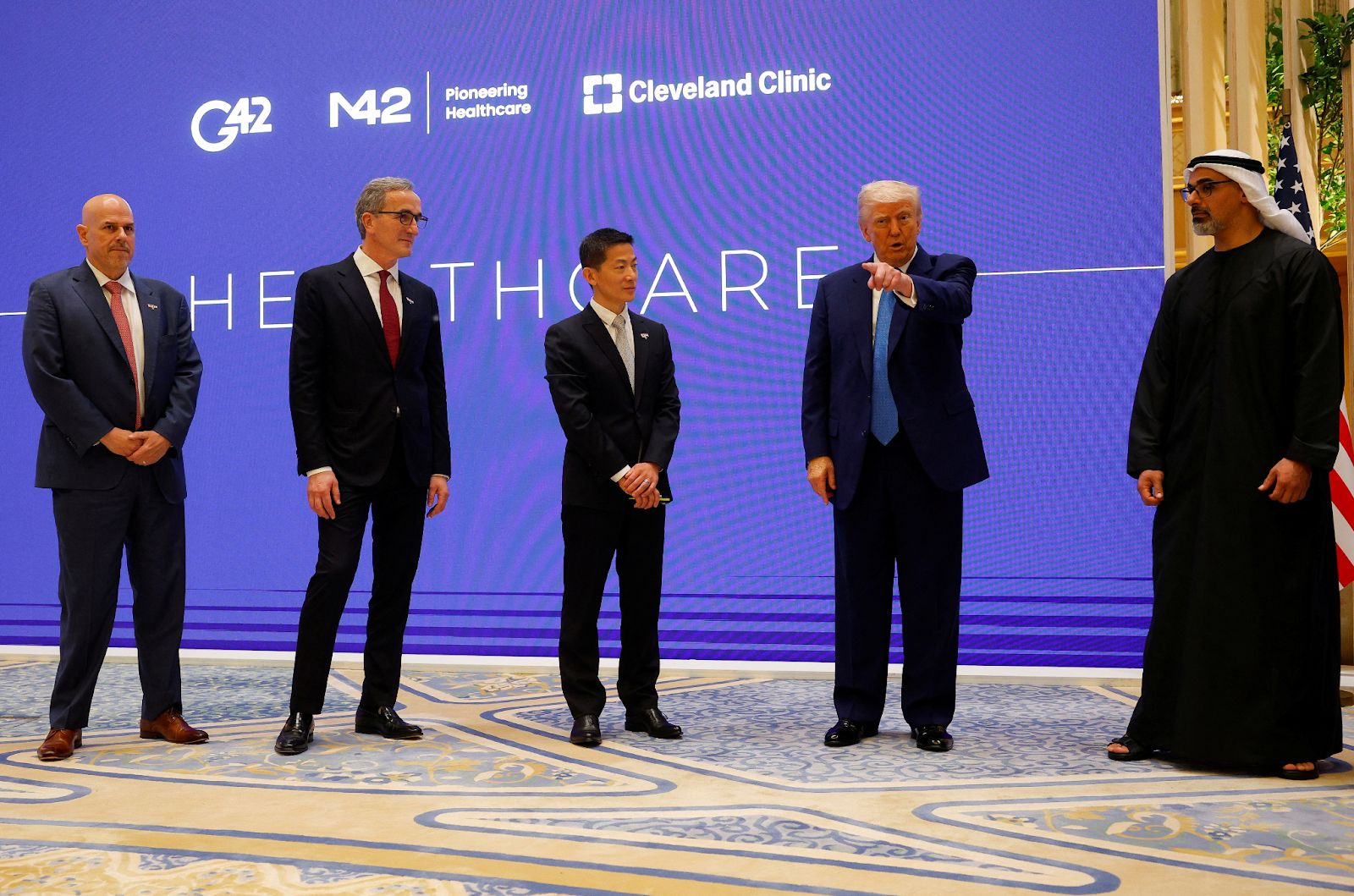  US President Donald Trump speaks next to Crown Prince of Abu Dhabi Sheikh Khaled bin Mohamed bin Zayed Al Nahyan, CEO of Cleveland Clinic Tom Mihaljevic, and CEO of G42 Peng Xiao as he attends a business forum at Qasr Al Watan during the final stop of his Gulf visit, in Abu Dhabi, UAE, May 16, 2025.