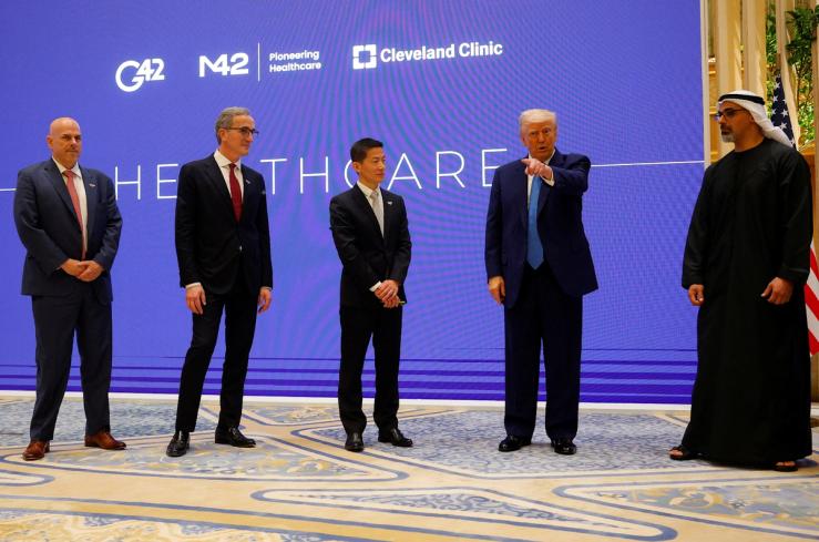 US President Donald Trump speaks next to Crown Prince of Abu Dhabi Sheikh Khaled bin Mohamed bin Zayed Al Nahyan, CEO of Cleveland Clinic Tom Mihaljevic, and CEO of G42 Peng Xiao as he attends a business forum at Qasr Al Watan during the final stop of his Gulf visit, in Abu Dhabi, UAE, May 16, 2025.