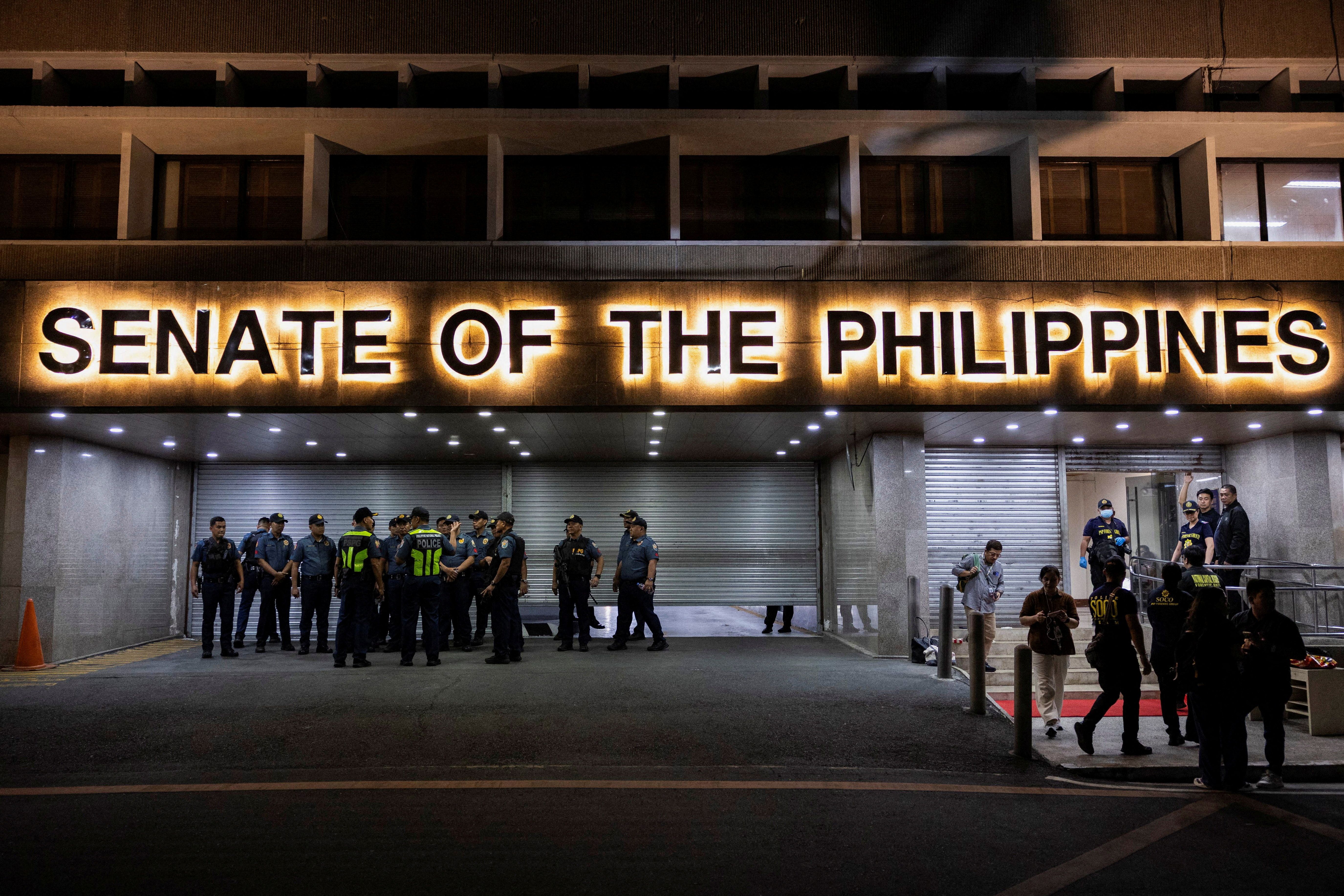 Police officers stand outside the Senate building, after gunshots were heard at the Philippine Senate.
