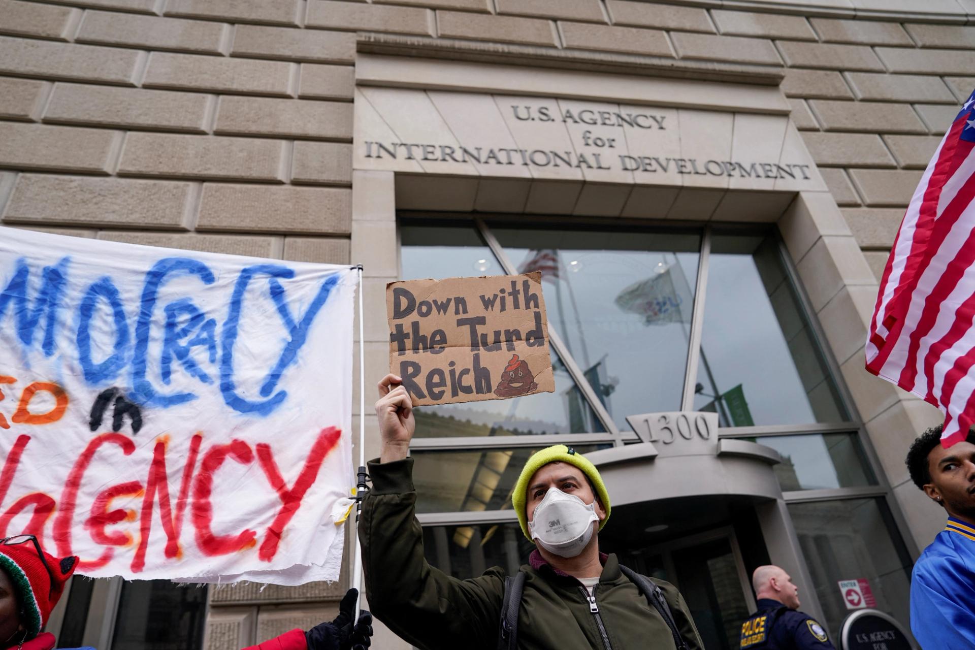 People hold placards outside the USAID building, Washington, US, February 3, 2025.