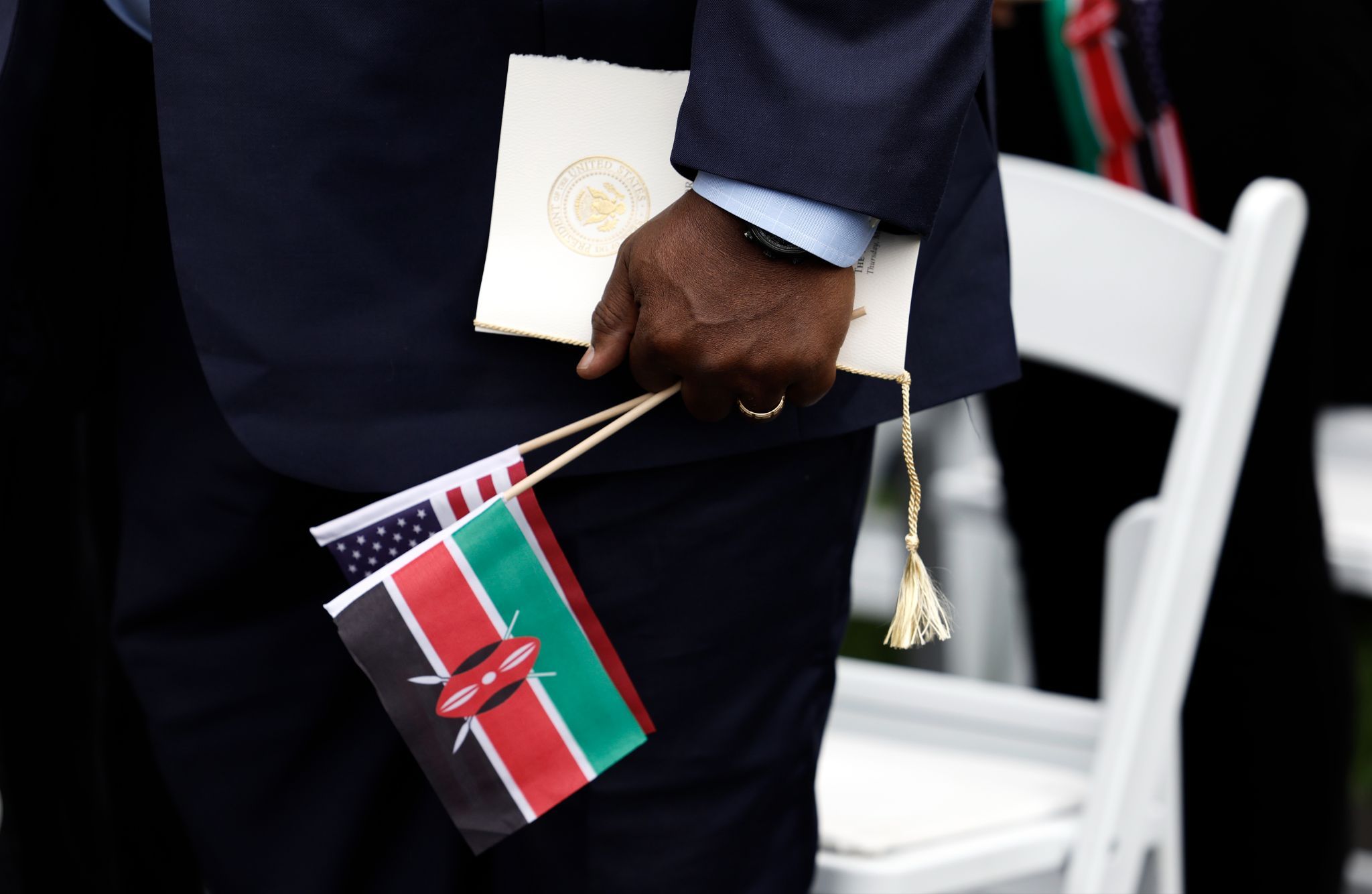 An audience member holds a Kenyan and an American flag during the arrival ceremony for Kenyan President William Ruto at the White House in 2024.