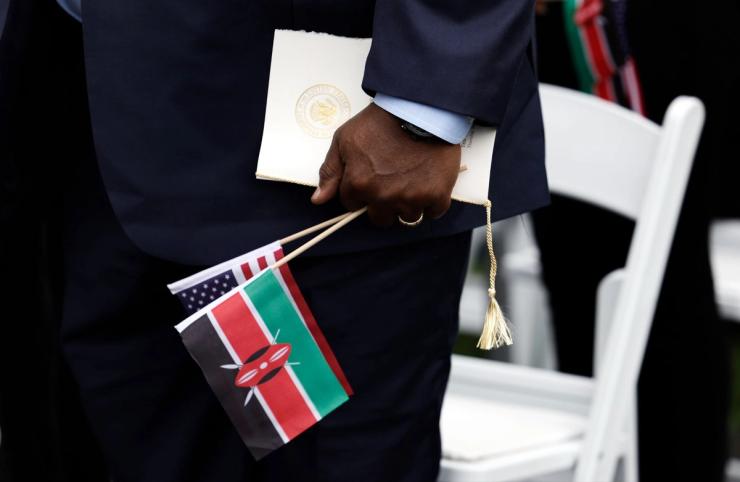 An audience member holds a Kenyan and an American flag during the arrival ceremony for Kenyan President William Ruto at the White House in 2024.