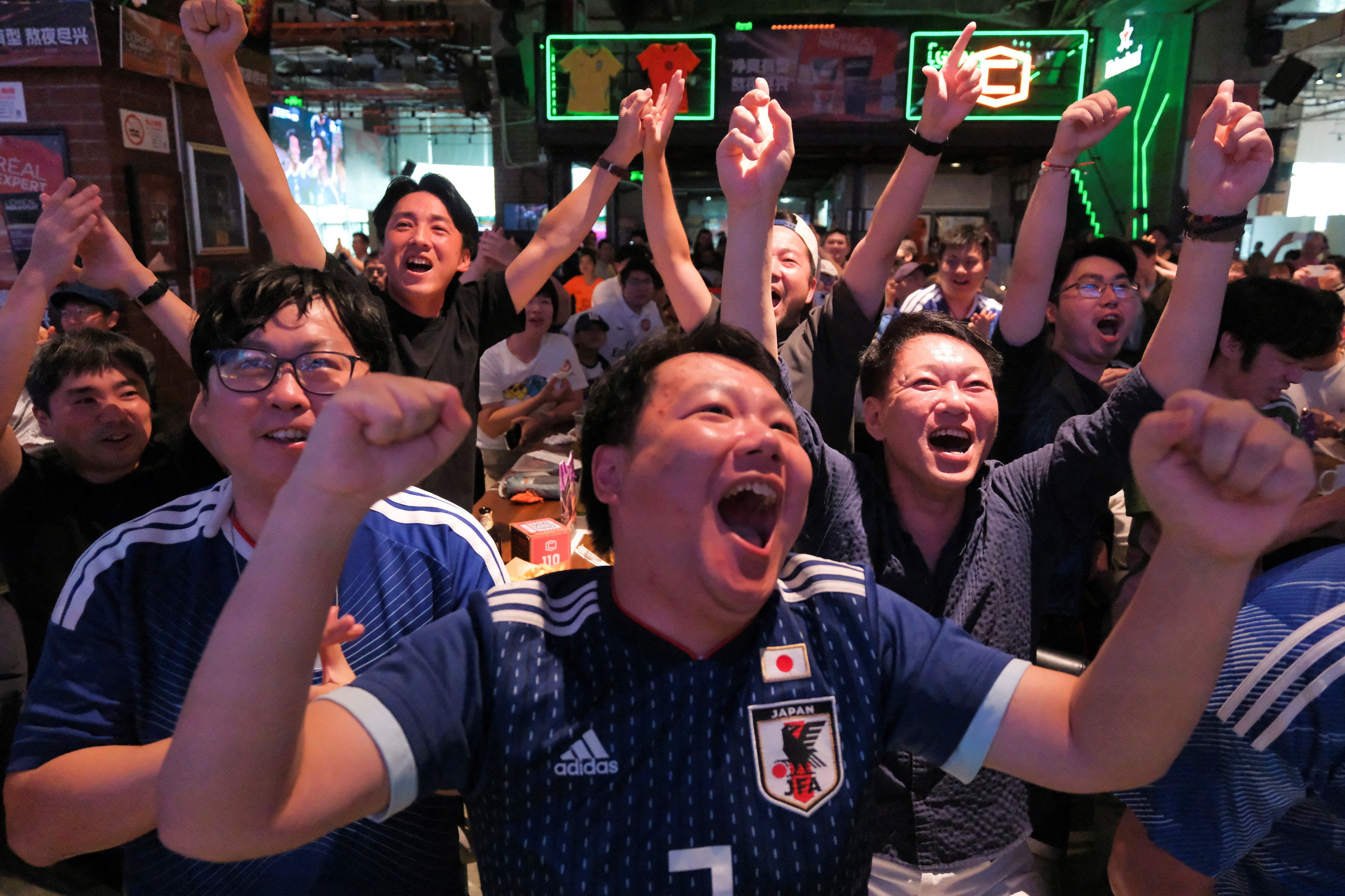 Soccer fans react during a FIFA World Cup match between Japan and Tunisia