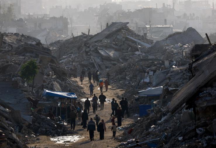 Gazans walk amid destroyed structures