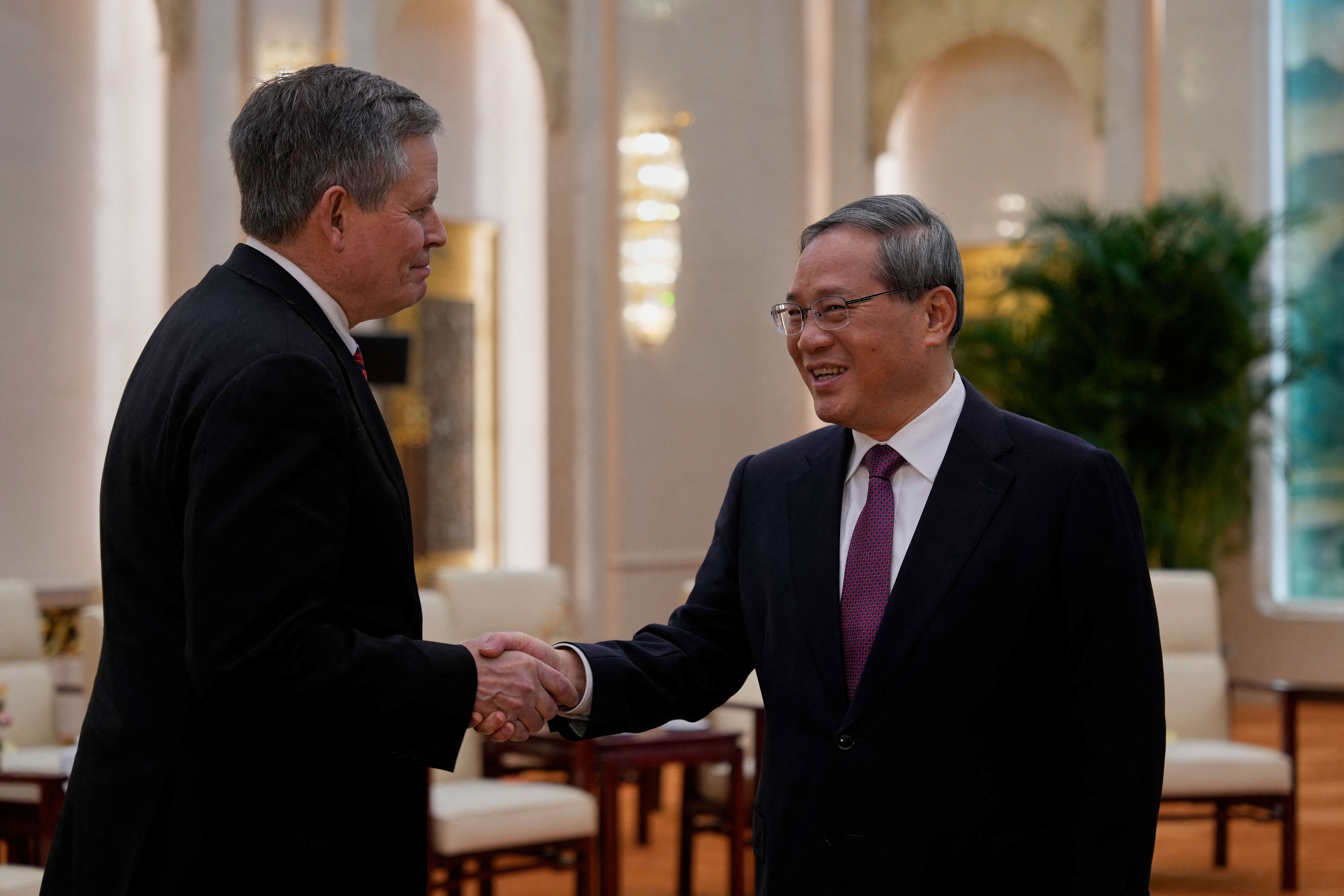 Chinese Premier Li Qiang, right, and Sen. Steve Daines, R-Mont., left.