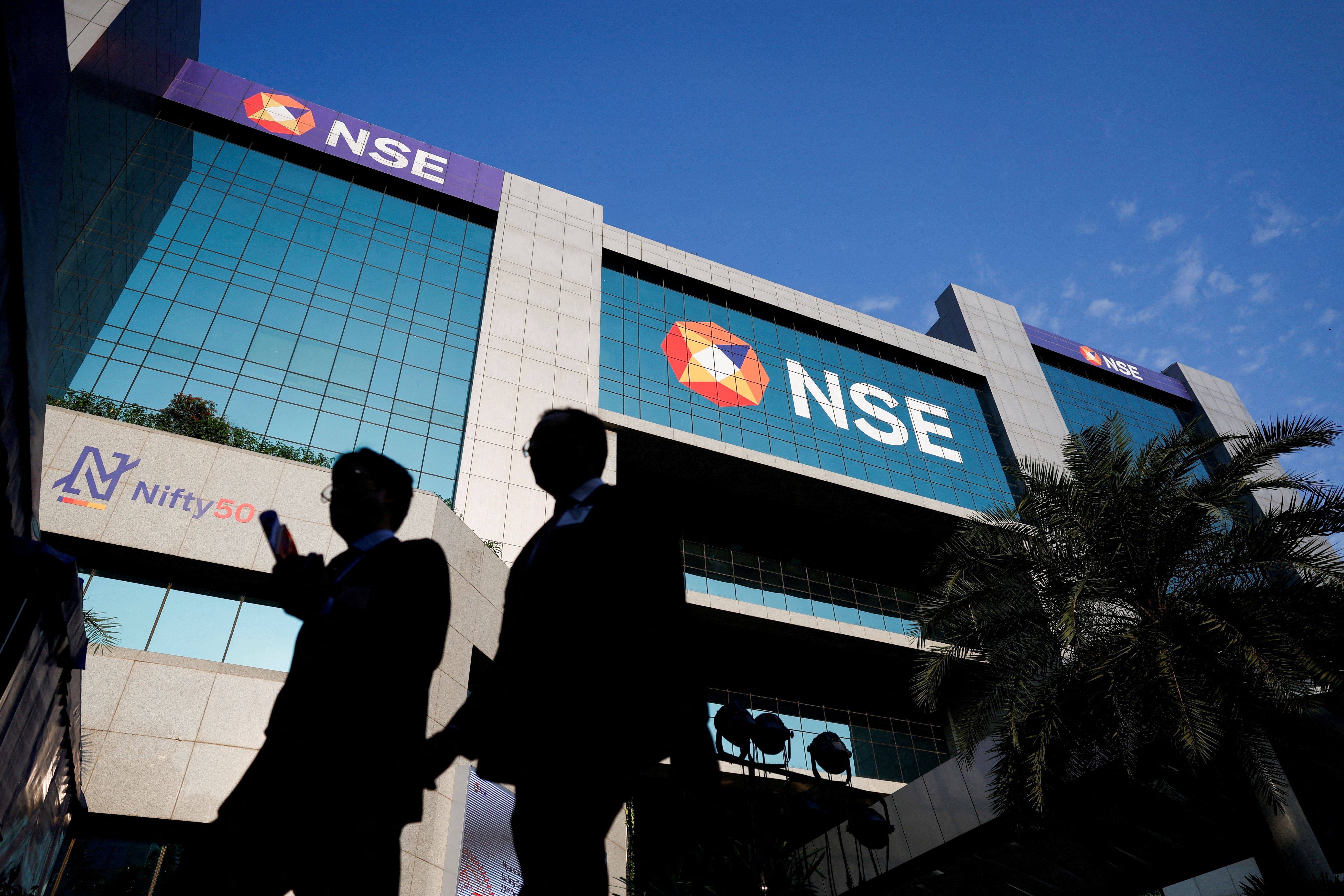 People walk outside the National Stock Exchange (NSE) in Mumbai.