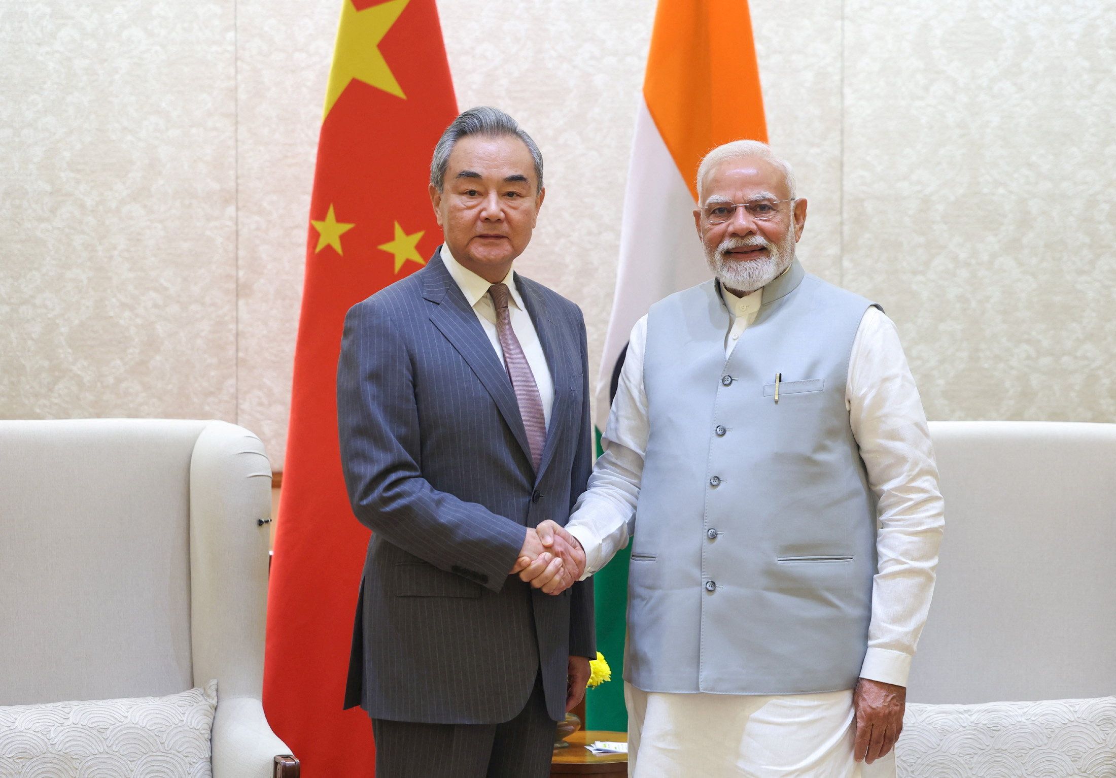 India’s Prime Minister Narendra Modi shakes hand with Chinese Foreign Minister Wang Yi.