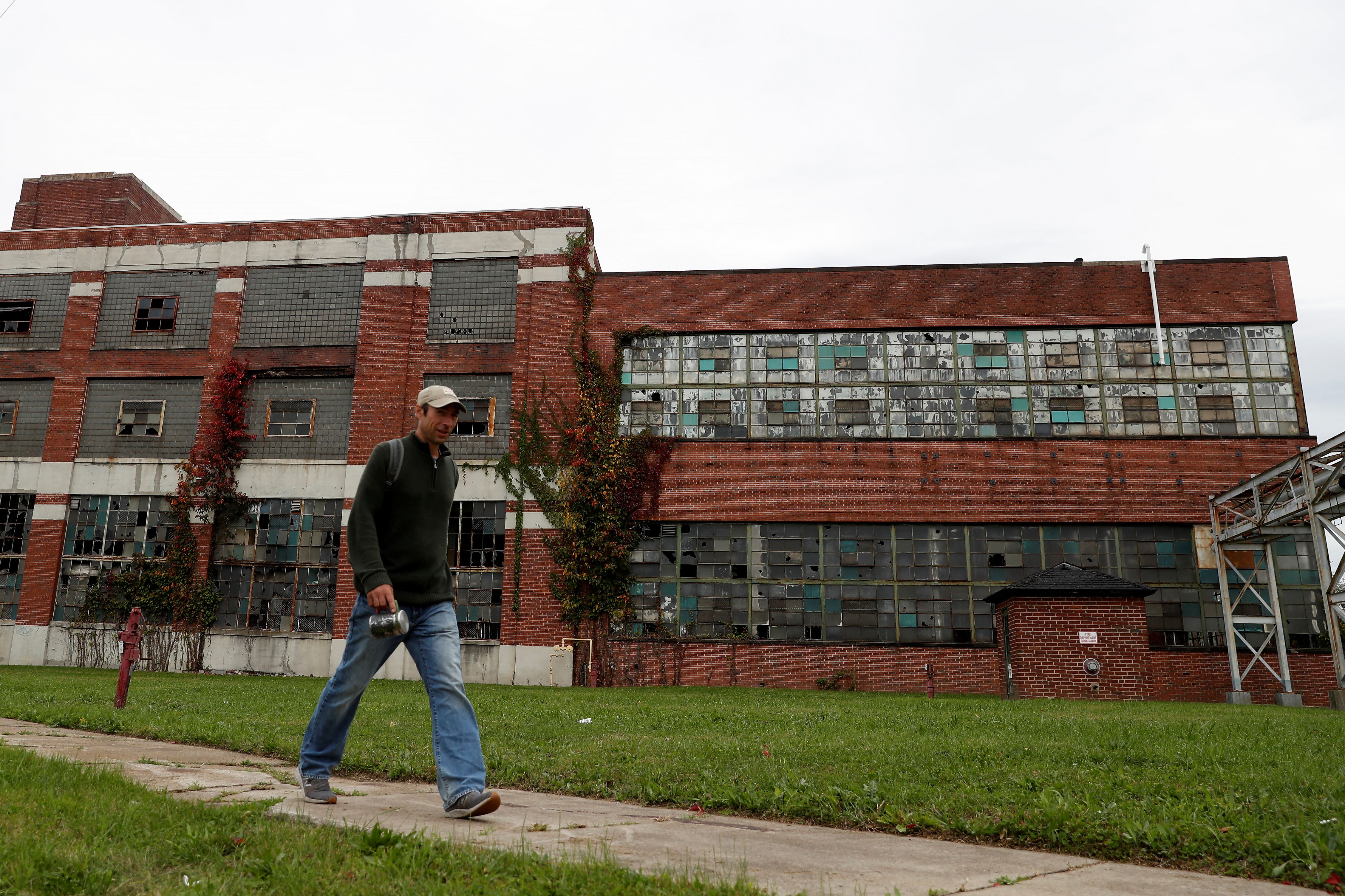 	A man walks past an abandoned Packard Electric Company building in Warren, Ohio