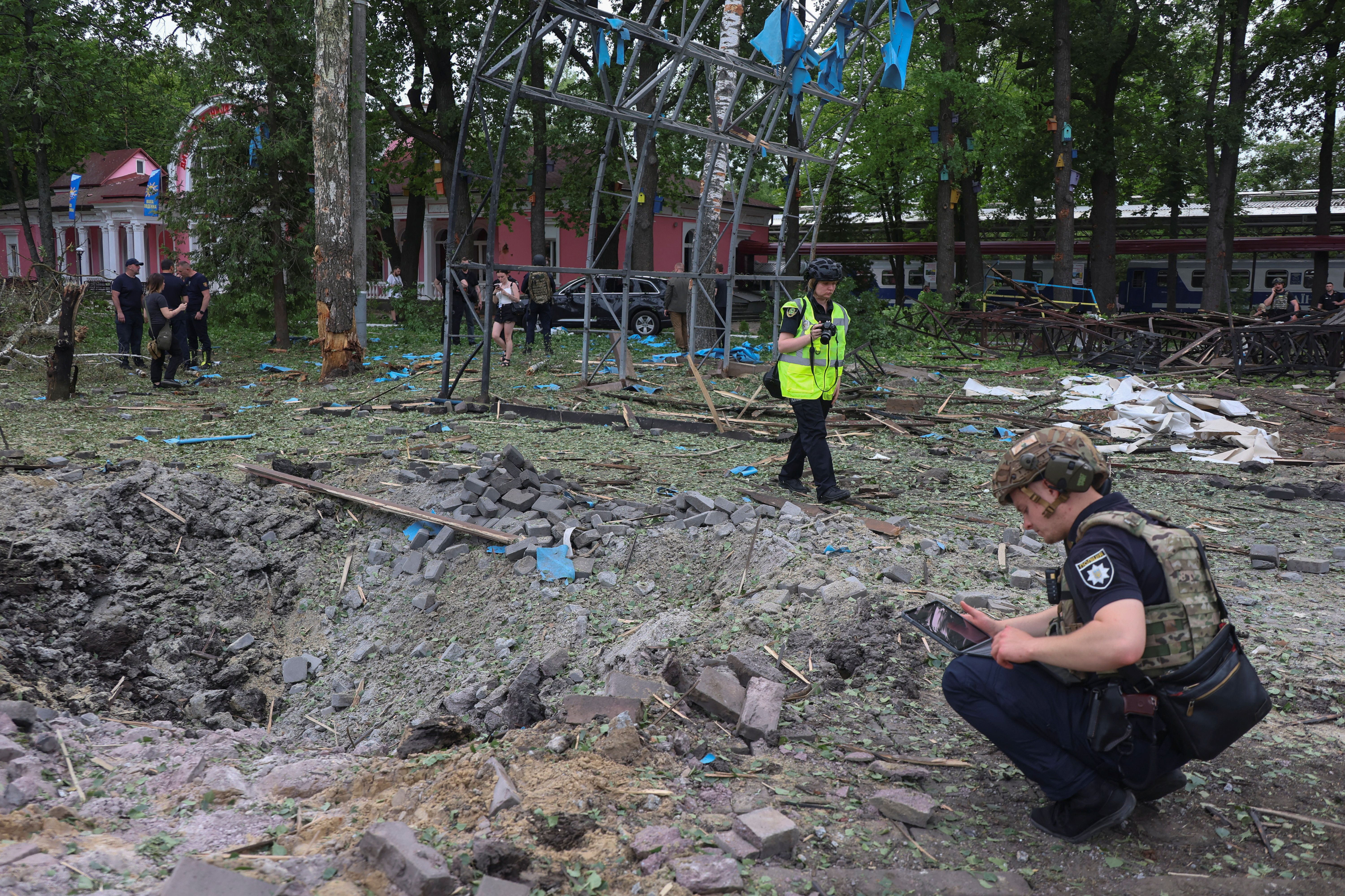 Police officers inspect a crater that appeared after a Russian air strike at a compound in Children’s Railway in a park, amid Russia’s attack on Ukraine, in Kharkiv, Ukraine June 7, 2025.