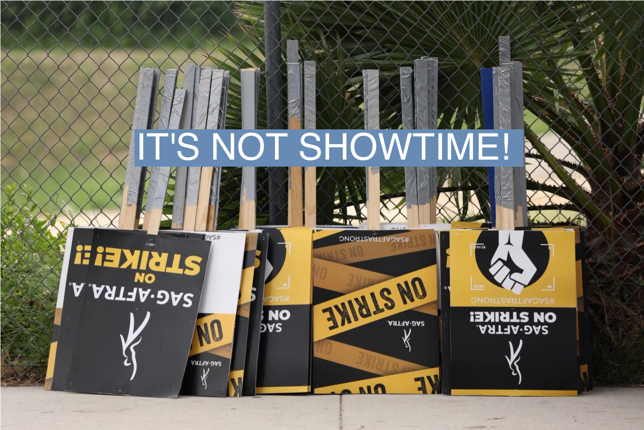 Signs at a SAG-AFTRA and Writers Guild of America rally