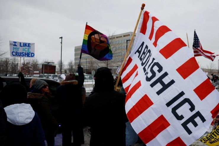 A protestor holding an “Abolish ICE” flag.