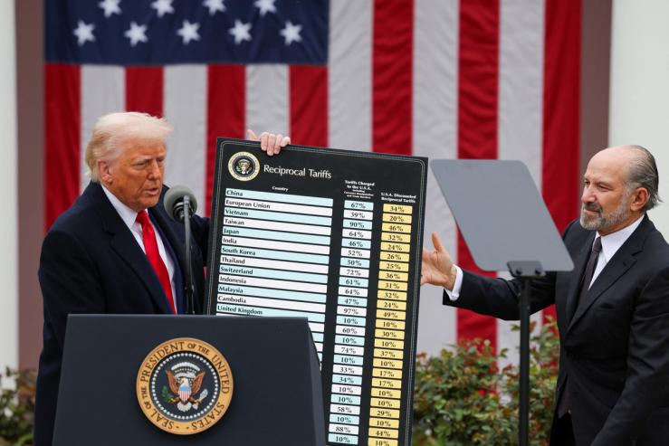 U.S. President Donald Trump holds a chart next to U.S. Secretary of Commerce Howard Lutnick as Trump delivers remarks on tariffs in the Rose Garden at the White House in Washington, D.C., U.S., April 2, 2025