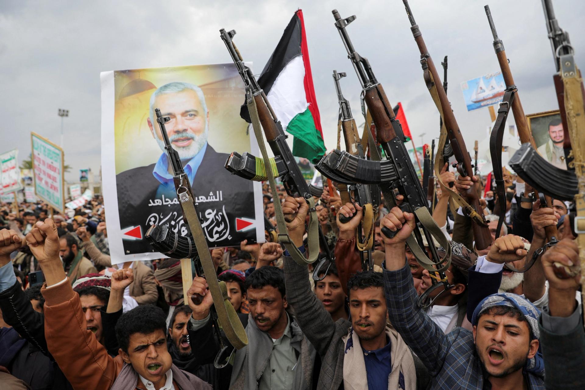 FILE PHOTO: Protesters, mainly Houthi supporters, hold firearms next to a poster of assassinated Hamas chief Ismail Haniyeh, at the rally to show solidarity with Palestinians in the Gaza Strip, in Sanaa, Yemen, August 2, 2024. REUTERS/Khaled Abdullah/File Photo