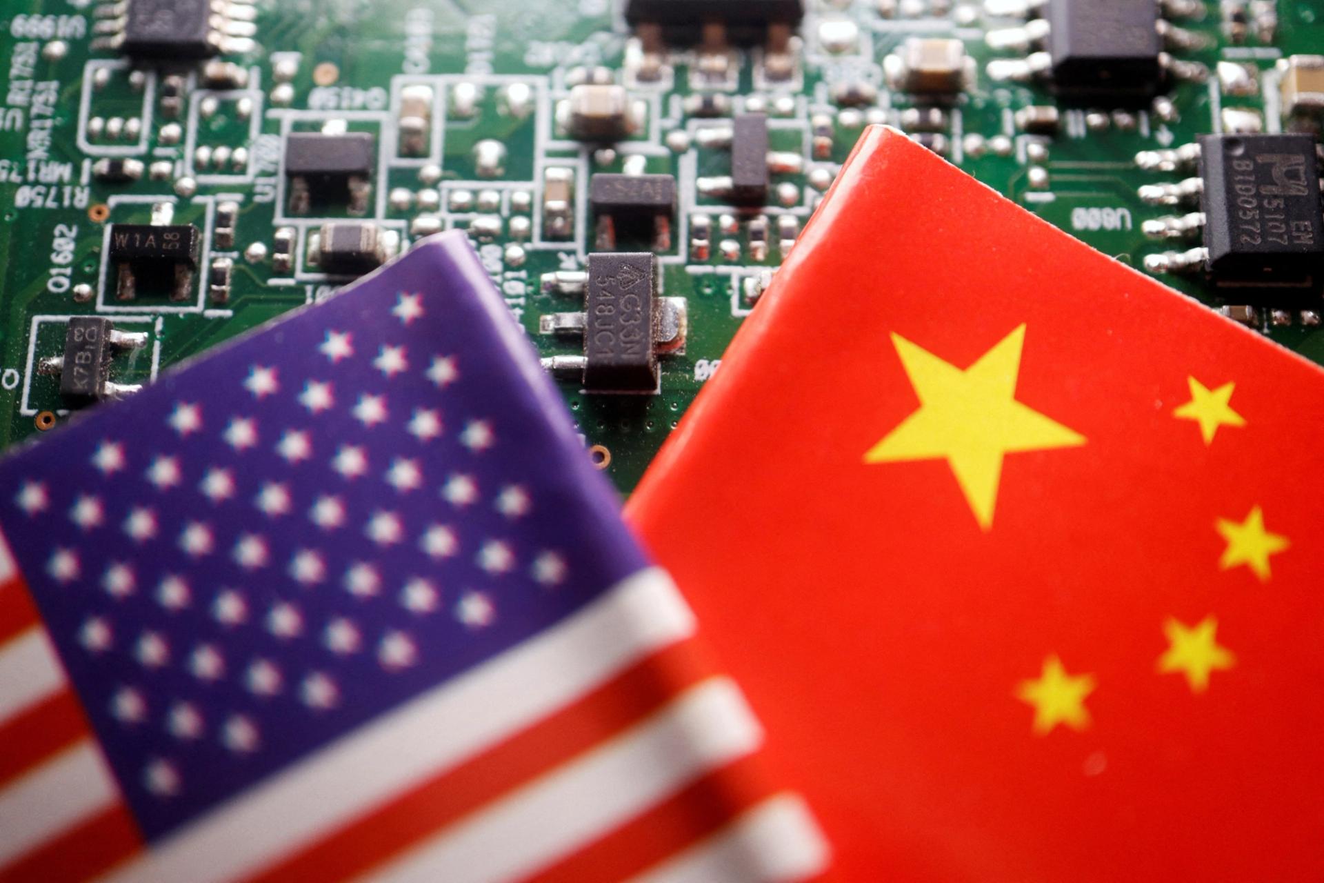 Flags of China and the US displayed on a printed circuit board with semiconductor chips. 