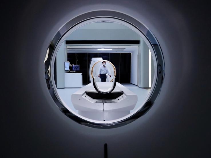 A man is seen through a CT scanner at the showroom of the medical imaging equipment maker Beijing Wandong WDM Medical Technology Co. during a government organised tour of the facilit.
