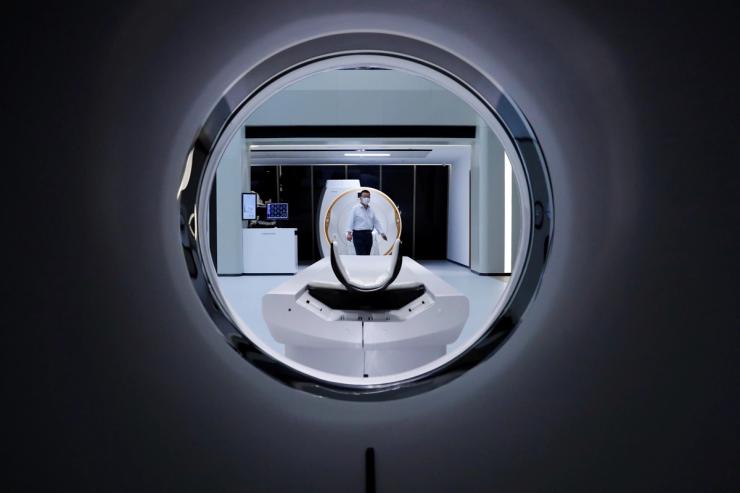 A man is seen through a CT scanner at the showroom of the medical imaging equipment maker Beijing Wandong WDM Medical Technology Co. during a government organised tour of the facilit.
