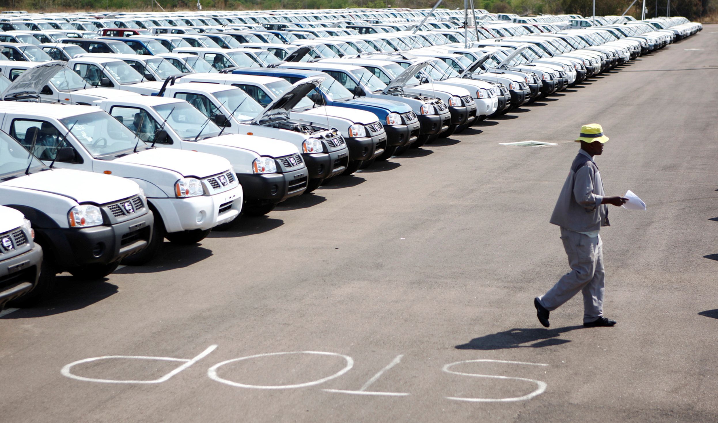 A worker walks near a row of cars at Nissan’s manufacturing plant in Rosslyn, outside Pretoria.