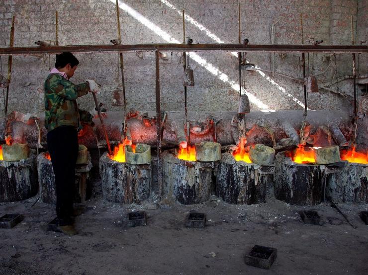 A worker at the Jinyuan Company’s smelting workshop stokes the pots containing the rare earth metal Lanthanum near the town of Damao, located in China’s Inner Mongolia Autonomous Region