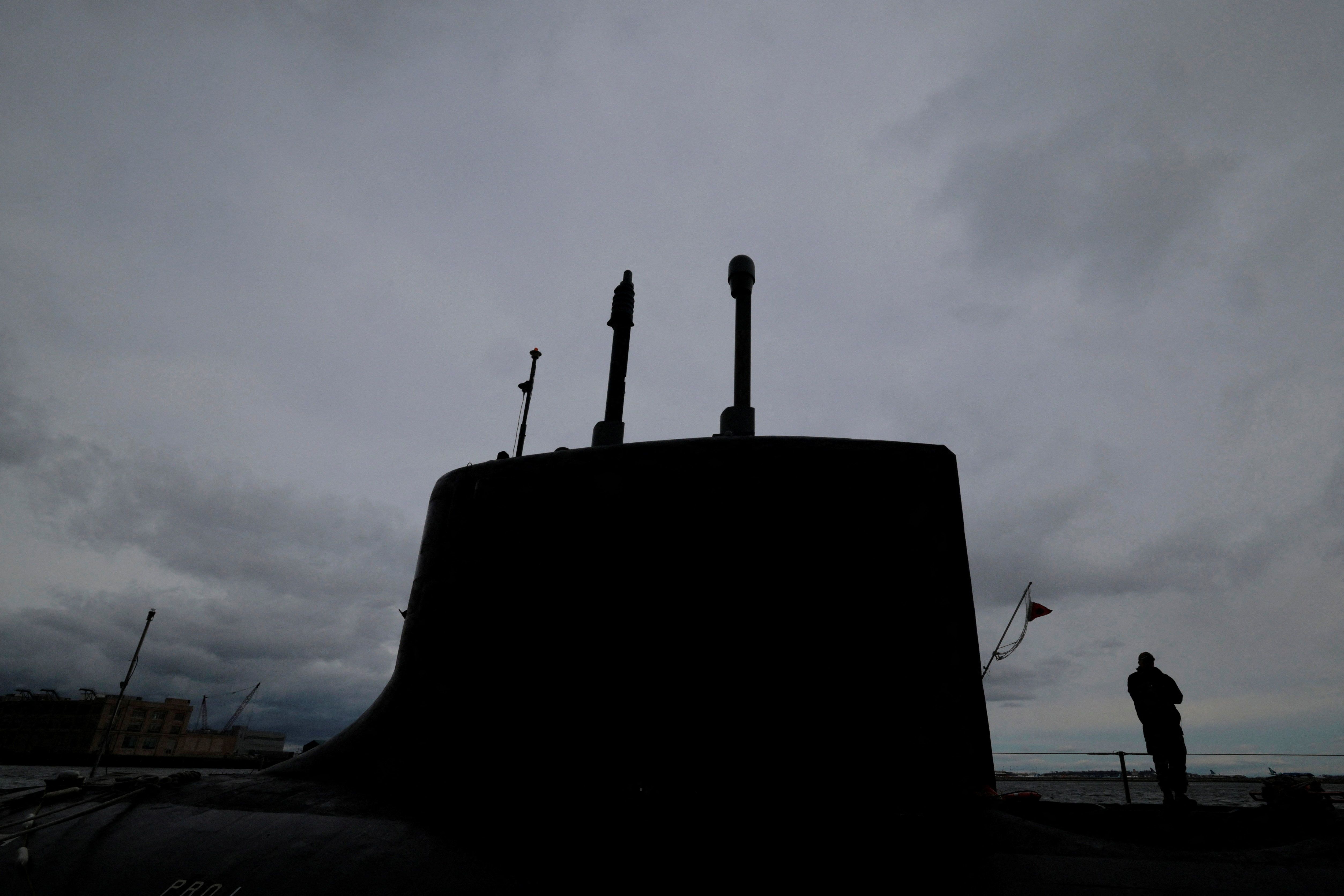 A crew member stands on the deck of the Virginia-class fast attack submarine USS Massachusetts